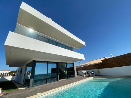 a large house with a swimming pool in front of it at Sunrise Villa in Sagres