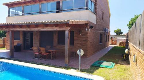 a house with a swimming pool next to a building at Chalet moderno con PISCINA en Calafell in Calafell