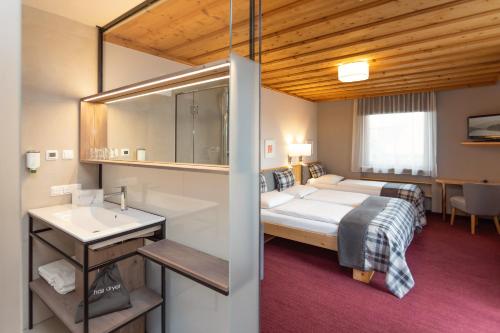 1 dormitorio con cama, lavabo y espejo en Hotel Gasthof Zum Kirchenwirt, en Puch bei Hallein