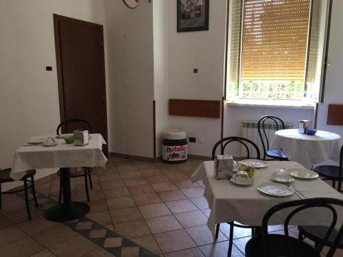 a dining room with two tables and chairs and a window at La Tegola in Como