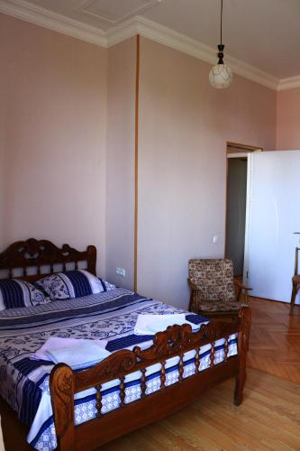 a bedroom with a large bed and a chair at Sighnaghi Inn in Sighnaghi