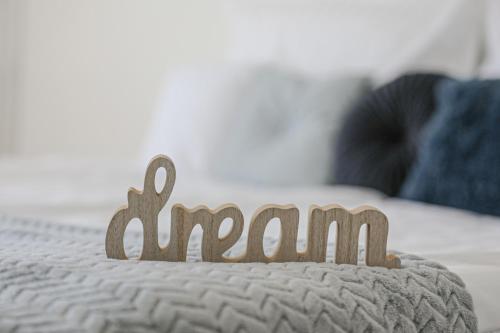 a wooden sign on top of a bed at Villa Grande Hévíz in Hévíz