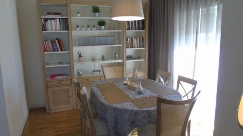 Oporto Beach في Gulpilhares: غرفة طعام مع طاولة ورف كتاب