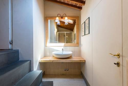 a bathroom with a sink and a mirror at Nella Torre del Poschi Penthouse with Roof Terrace in Pisa
