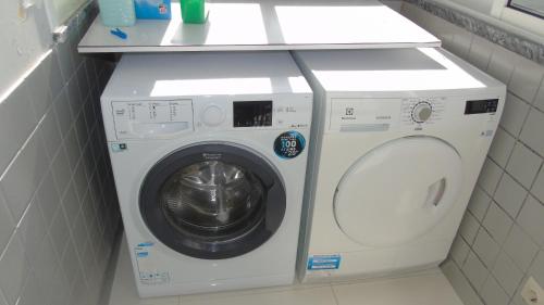 a white washer and dryer in a bathroom at Oporto Beach in Gulpilhares