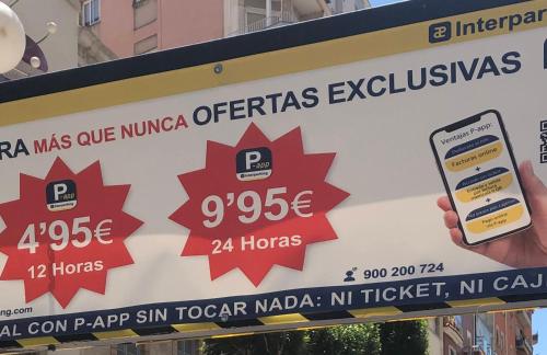 a person holding a cell phone in front of a sign at TORREPEREA- Piso completo in Jaén