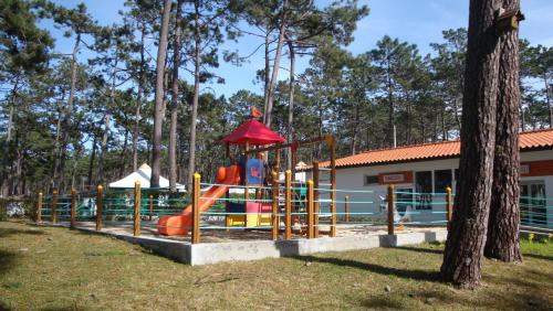 a playground with a slide in a park at Parque De Campismo Orbitur Sao Pedro De Moel in São Pedro de Moel