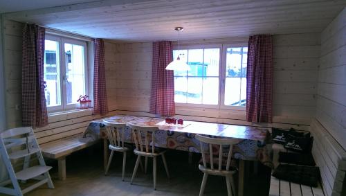 a dining room with a table and chairs and windows at Ferienhaus Schindeler in Mellau