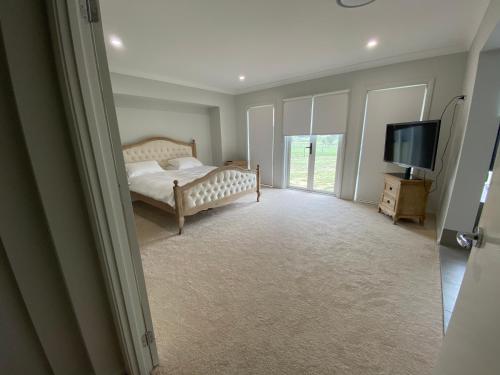 Schlafzimmer mit einem Bett und einem Flachbild-TV in der Unterkunft Rosehill Vines in Millfield