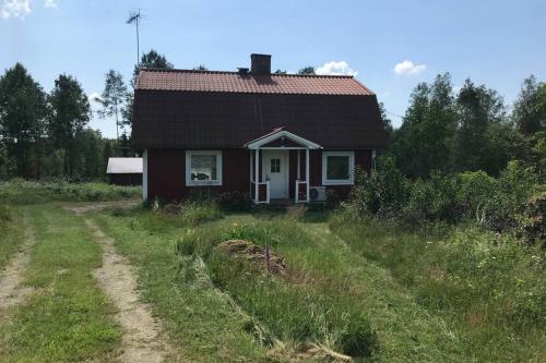 a small house in a field with a dirt road at Holiday home in Småland in Ryd