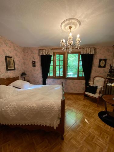 une chambre avec un lit et un lustre dans l'établissement La Haie à Cerf, à Watronville