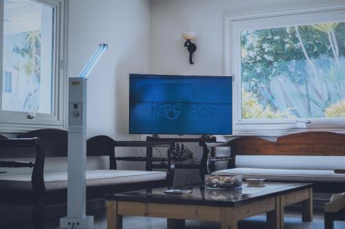 - un salon avec une télévision et une table dans l'établissement Keros Art Hotel, à Koufonisia