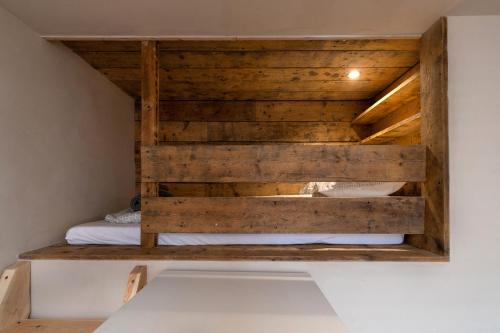 a bed in a room with a wooden wall at Snowdon Street in Llanberis