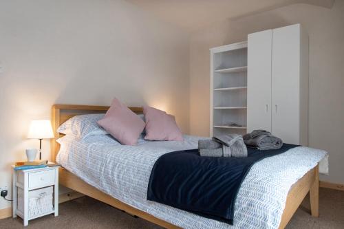 a bedroom with a large bed with pink pillows at Snowdon Street in Llanberis