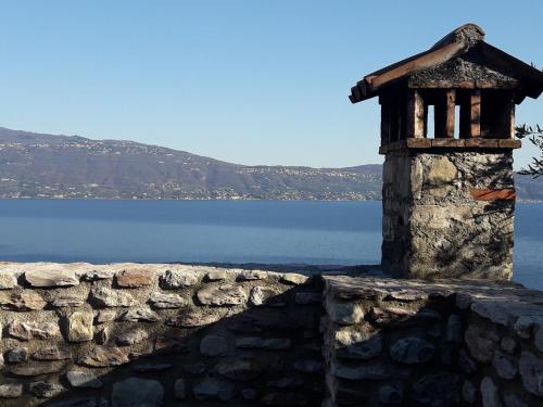 a stone wall next to a body of water at Cà del borgo Historic Village in Toscolano Maderno
