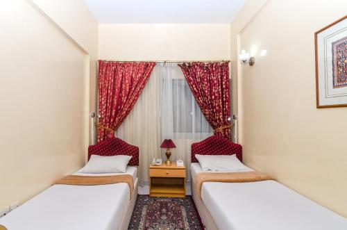 zwei Betten in einem Zimmer mit Fenster in der Unterkunft Royalton Hotel in Dubai