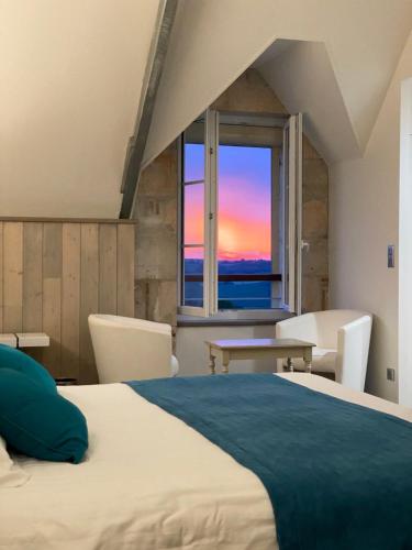 una camera con un grande letto e una finestra di Logis Hostellerie des Ducs a Duras