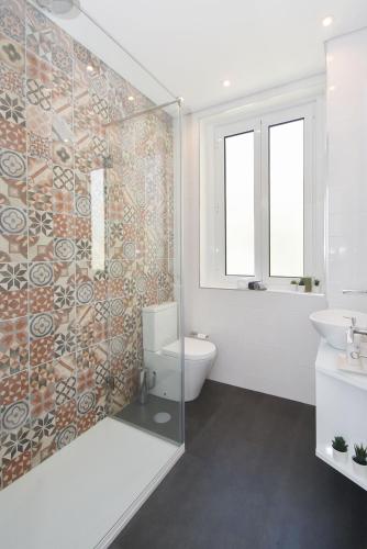 a bathroom with a toilet and a glass shower at Oporto Lovely House in Porto