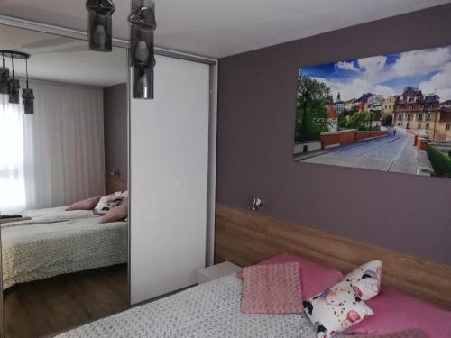 a bedroom with a mirror and a tv on the wall at Kompozytor in Lublin