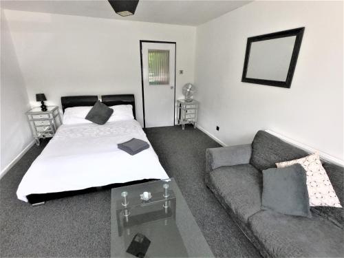 een slaapkamer met een bed en een bank bij Town Centre Studio Flat! in Basingstoke