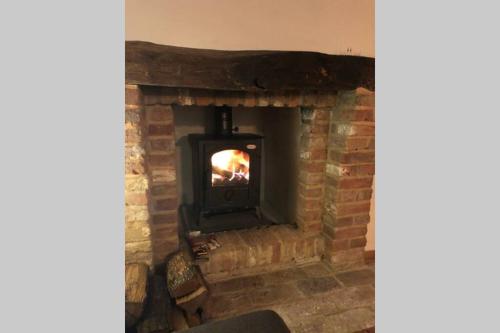 a brick fireplace with a fire in it at Angliiska Vila in Arbanasi