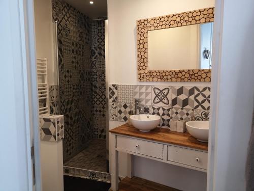 uma casa de banho com 2 lavatórios e um espelho em Une affaire de famille em Le Portel