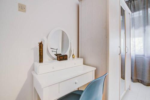 a dressing table with a mirror and a blue chair at Vacation home Korina in Senj