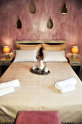 a doll is sitting on a bed with two lamps at Magdalena Seaside Apartments in Nea Roda