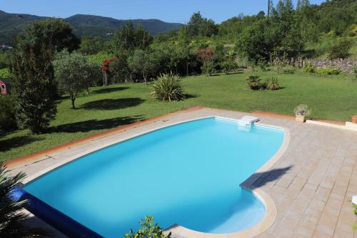 a large blue swimming pool in a yard with a garden at chambres d'hôtes du capimont in Hérépian