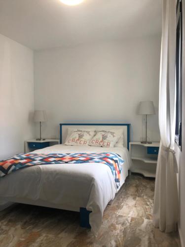 ein Schlafzimmer mit einem Bett, zwei Tischen und einem Fenster in der Unterkunft Lujan 6F entre sueños y realidad in Puntallana