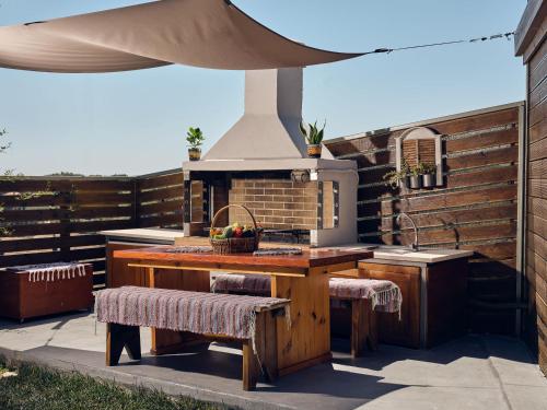 an outdoor kitchen with a table and two benches at Tramonto Villa in Volímai