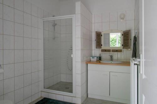 La salle de bains est pourvue d'une douche et d'un lavabo. dans l'établissement Knus tuin-appartement vlakbij Nijmegen voor 2 personen, à Molenhoek