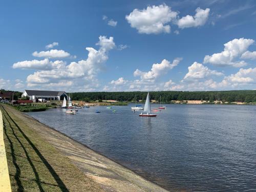 a sailboat on a river with boats on it at apartament LeśnaCedzyna in Cedzyna
