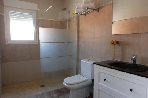 łazienka z toaletą, umywalką i oknem w obiekcie Apartamento con Piscina ADULTS ONLY w mieście Chiclana de la Frontera