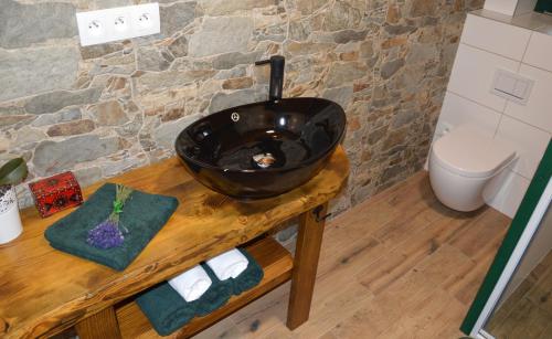 a bathroom with a black sink on a wooden table at Apartmán Elenka in Zuberec