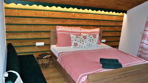 a bedroom with a bed with a wooden wall at Apartmán Elenka in Zuberec