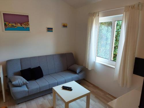 a living room with a blue couch and a table at Pension Oaza in Hvar