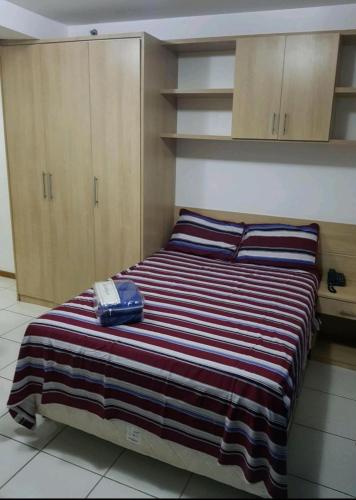 a bedroom with a bed with a phone on it at FLAT BIARRITZ SETOR HOTELEIRO NORTE QUARTO 106 in Brasília