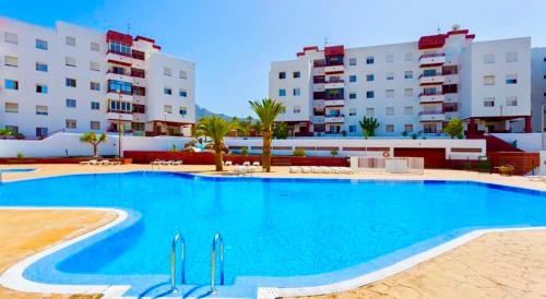 a large swimming pool in front of some buildings at SEA-VIEW APARTMENT WITH a TENNIS COURT in Adeje