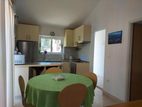 a kitchen with a table with a green table cloth on it at Pension Oaza in Hvar