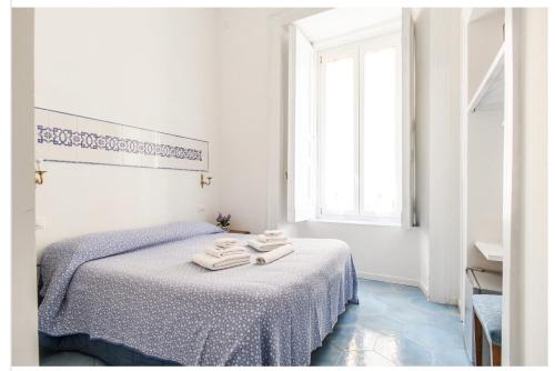 ナポリにあるIl Sole di Montesantoの白いベッドルーム(タオル付きのベッド付)