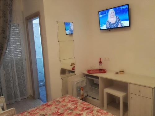 a bedroom with a tv on the wall and a bed at Bouganville Bed & Breakfast Stegna in Archangelos