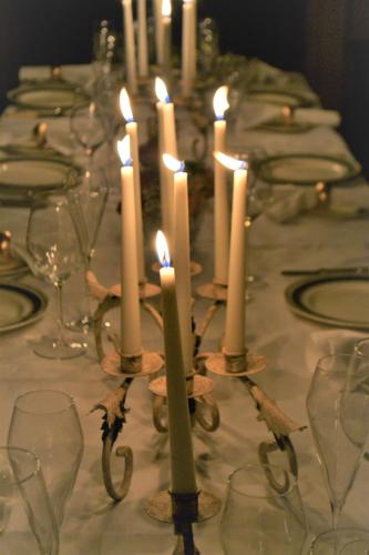 a group of candles on a table with glasses at Sissinghurst Castle Farmhouse in Sissinghurst