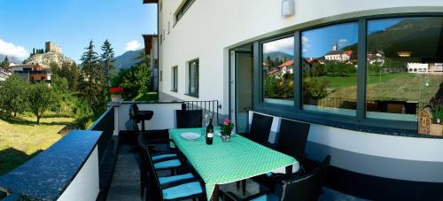 a green table and chairs on a balcony with a view at Haus Helvetia in Ladis