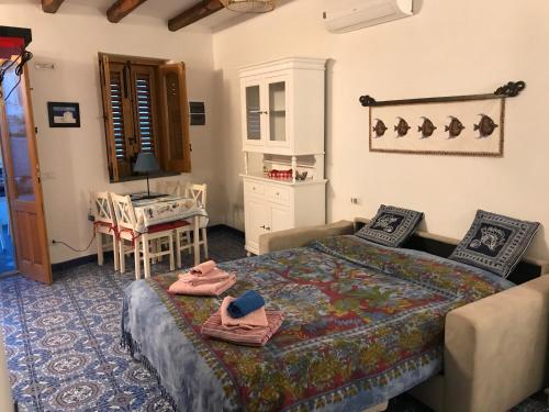 een slaapkamer met een bed en een tafel en stoelen bij Casa Nonna Maria in Stromboli