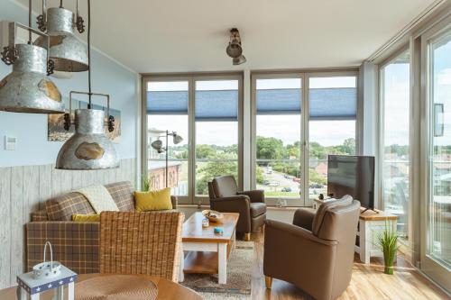 a living room with a couch and chairs and windows at Waterbed Barth in Barth