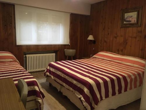 a hotel room with two beds and a window at Piuké in San Carlos de Bariloche