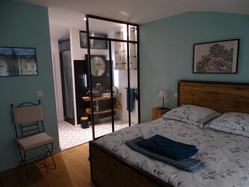 une chambre avec un lit, une chaise et un miroir dans l'établissement Mas de la Cadenière, à Saint-Rémy-de-Provence