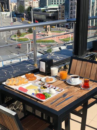 una mesa con una bandeja de comida en el balcón en Kartal Palace Taksim Square FAMİLY HOTEL, en Estambul