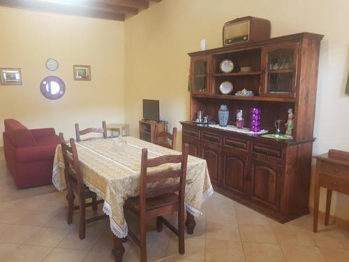 een eetkamer met een tafel en een bank bij Barondi Holiday House in Piedimonte Etneo